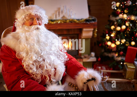 Portrait of real Santa Claus near decorated Christmas tree Stock Photo