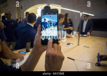 A customer in the Apple store in Grand Central Terminal in New York uses the camera in a new iPhone 8 Plus on Friday, September 22, 2017, the first day it went on sale.  Demand for the new phones has been sluggish  as the phone has limited new features and diehard Apple aficionados wait for the iPhone X in November. (© Richard B. Levine) Stock Photo