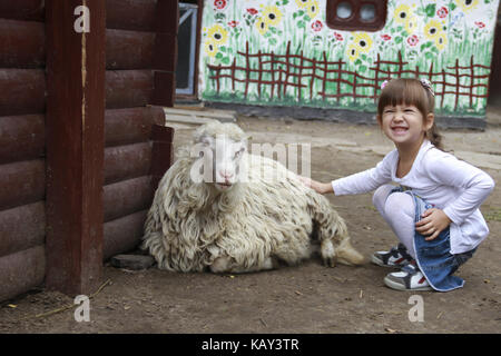 Little girl strokes lamb Stock Photo