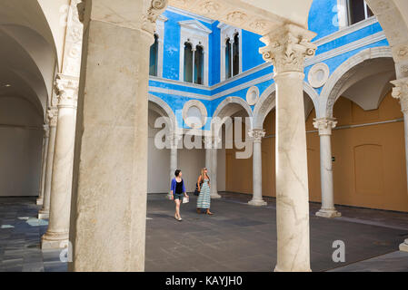 Women friends vacation, view of two young women tourists walking through the Renaissance courtyard in the Museo de Bellas Artes in Valencia, Spain. Stock Photo
