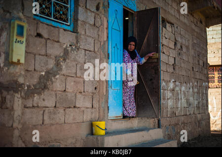 woman at the front of her house in Merzouga, Morocco Stock Photo