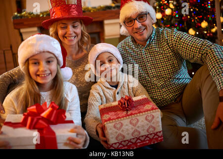 Happy family with Christmas gift at home together Stock Photo