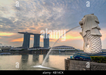 SINGAPORE - SEPTEMBER 11, 2017: Sunrise at Merlion Park with Marina Bay in the background. The Merlion is the city's most recognizable icon depicted a Stock Photo