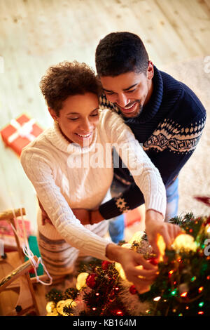 Afro couple in love decorated Christmas tree Stock Photo