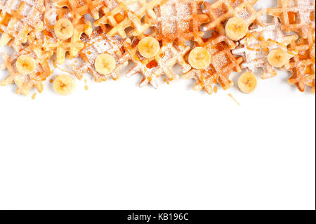Background with many small waffles with banana and honey on the white table Stock Photo