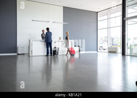 Passengers departing from business trip at hotel reception Stock Photo