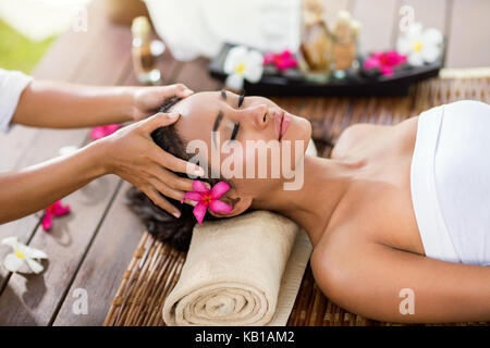 Masseur doing massage the head of an Asian woman in the spa salon Stock Photo