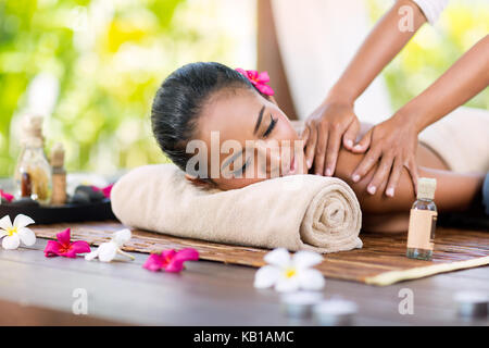 Masseur doing massage on female shoulder in the beauty salon Stock Photo
