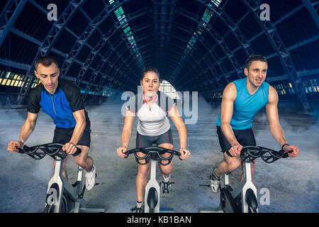 group of three people exercise on bike, spinning class, Stock Photo