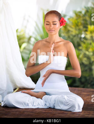Beautiful woman in Buda pose practicing yoga outside in nature, healthy lifestyle wellness concept Stock Photo