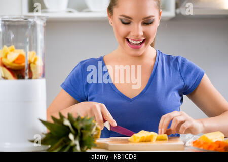 Happy young woman preparing healthy food Stock Photo