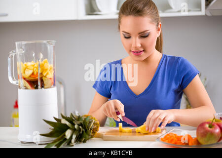 Healthy girl making fruits smoothies in kitchen Stock Photo