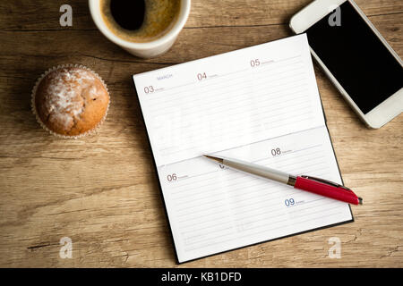 Open notebook on wooden desk, planning workweek Stock Photo