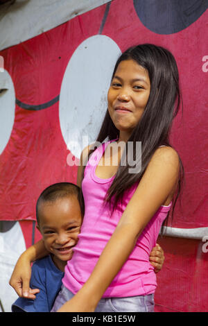 Portrait of a Filipino sister and brother in Ormoc, Leyte Island, Philippines. The girl is about twelve years old and the boy about seven. Stock Photo