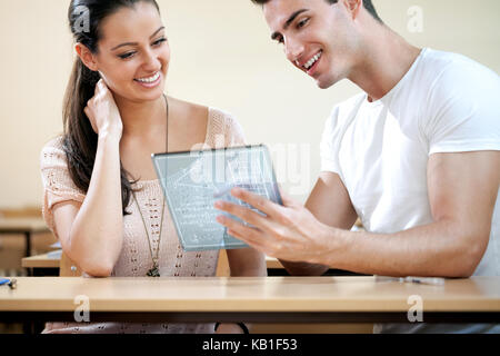 Couple of students using  futuristic digital tablet Stock Photo