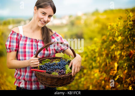 smiling  woman with basket full of grapes Stock Photo