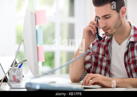 Busy man in office sitting at desk, back view Stock Photo