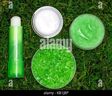 Cosmetics for lip skin care: sea salt, natural honey scrub with essential oils, lip cream and balm on green moss Stock Photo