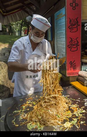 Person prepares food, Splendid China park, Shenzhin, Stock Photo