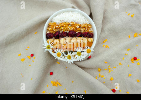 Top view muesli with nuts, dried fruits and daisies Stock Photo