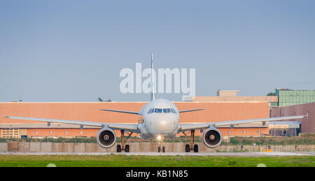 Front view of airplane with full wingspan at airport on taxi way with plenty of copy space Stock Photo