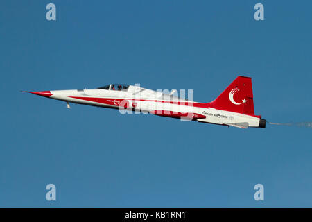 NF-5 pilot of the Turkish Stars military display team waving to spectators while flying a solo slow pass at an airshow Stock Photo