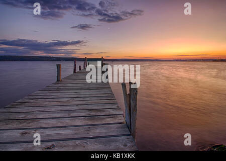 Beauty and calm sunset on lake with wooden pier Stock Photo