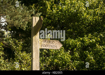 A Wooden Public Footpath Sign with a leafy background. Stock Photo