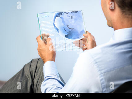 Young man with transparent futuristic tablet,  concept actual future innovative ideas and best technologies humanity. Stock Photo