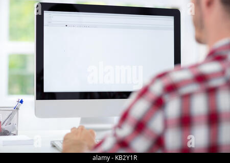 Portrait from behind of young man  using computer Stock Photo
