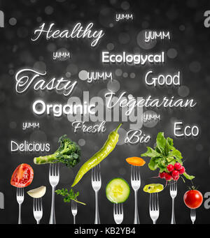 Raw vegetables on forks over design background Stock Photo