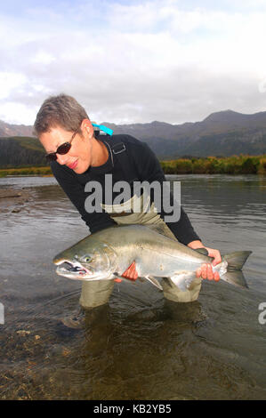 A woman fishing for salmon on a remote Alaska river Stock Photo