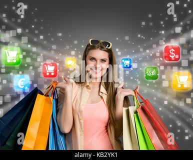 Happy woman shopping online with colorful icons in background Stock Photo