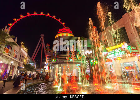 Tourists and visitors are enjoying the nighttime walking around the shoppes and stores next to The High Roller in Las Vegas, Nevada.