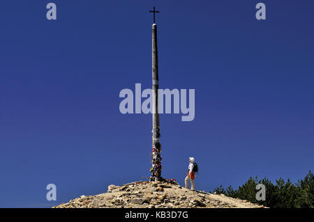 Spain, Way of St. James, pilgrim on the iron cross of Monte Irago, Stock Photo