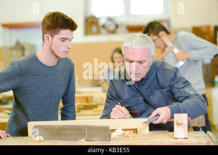 carpenter with apprentice in training period Stock Photo