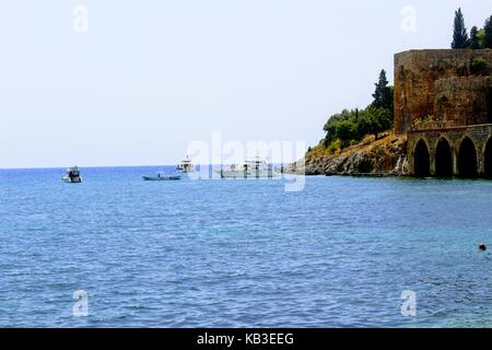 View from the embankment to the old shipyard Kızıl Kule and sea vessels (Antalya, Turkey) in July 2017. Stock Photo
