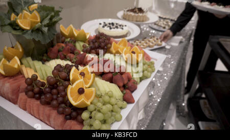 Different fresh fruits on wedding buffet table. Fruits and berries Wedding table decoration. Buffet reception fruit wines champagne. Wedding table decoration. Cherry Stock Photo