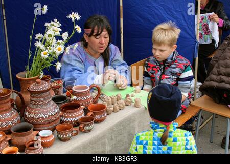 June, 2017, Odoev (Russia): Folk Festival "Grandfather Filimon's Tales" - master class on modeling clay toys. Stock Photo