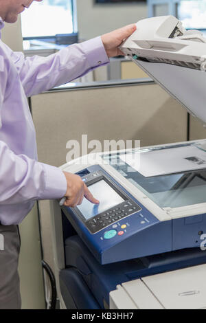 Male executive using photocopier at customer service center of electric power plant Stock Photo