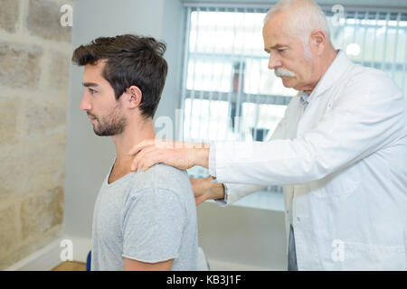 male chiropractor doing neck adjustment in a rehabilitation center Stock Photo