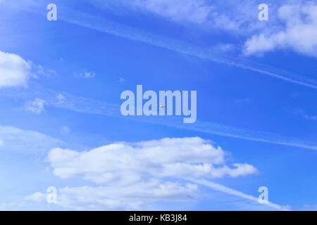 Quadrocopter hangs in the air against a clear blue sky. Stock Photo
