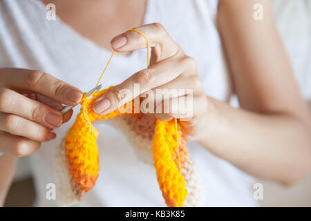 A woman knits a colored cloth. Hands close-up. Stock Photo