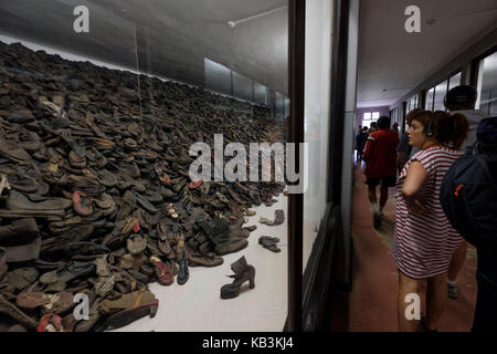 Tourists looking at piles of shoes belonging to prisoners at Auschwitz WWII Nazi concentration camp museum, Poland Stock Photo