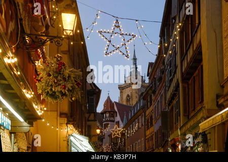 France, Haut Rhin, Colmar, Christmas decoration at Rue des Marchands, Maison Pfister and steeple of Saint Martin's Abbey Church Stock Photo