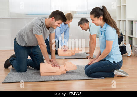 Group Of Students Learning Cpr On Dummy In Class Stock Photo