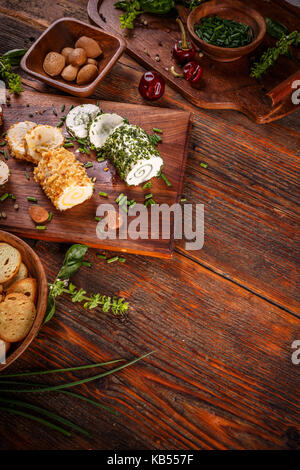 Spicy cheeses on vintage wooden cutting board Stock Photo