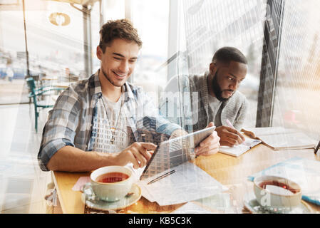 Positive students having fun in the cafe Stock Photo