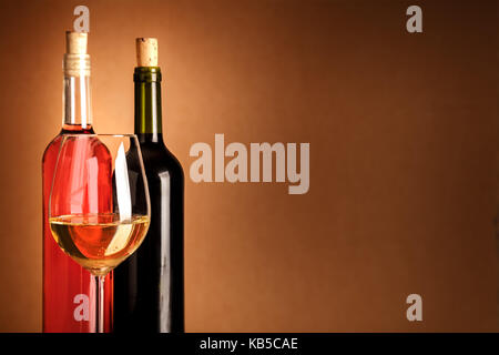 Glass of white wine in front of bottles with copyspace Stock Photo