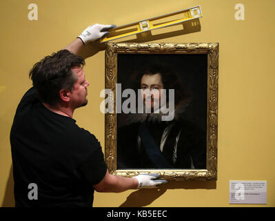 Museum technicians Jonny Hanna makes final adjustments as he hangs a rare 17th century portrait of the Duke of Buckingham, George Villiers, by Sir Peter Paul Rubens, on display at the Kelvingrove Art Gallery and Museum in Glasgow. Stock Photo